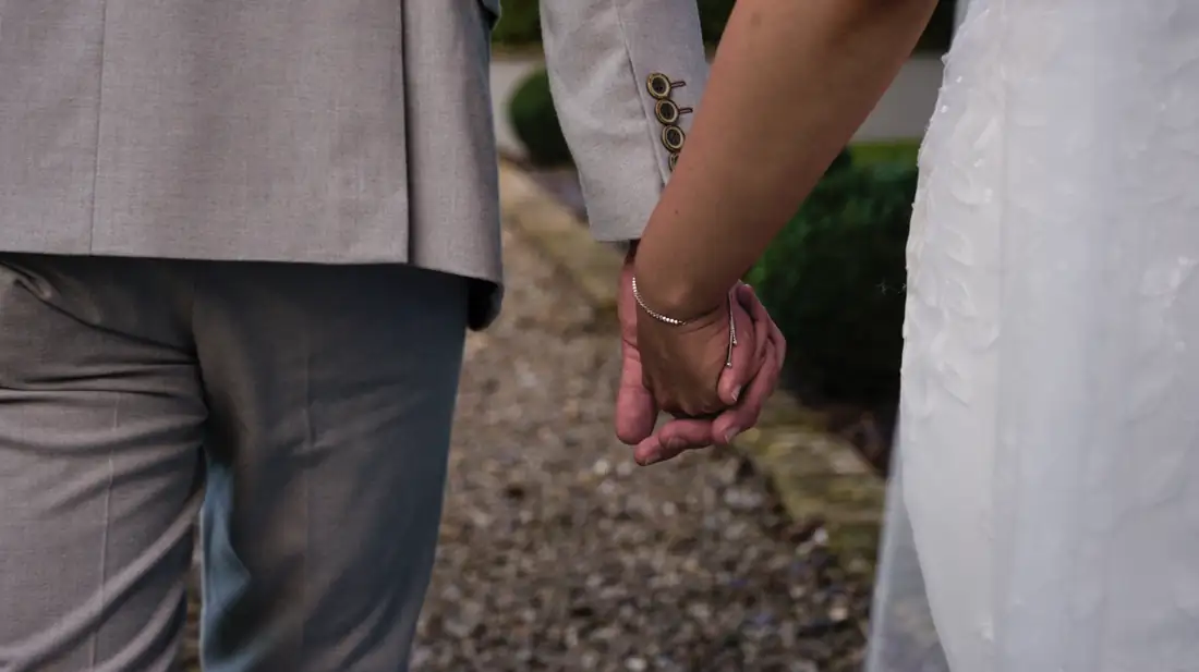 A newly married couple holding hands